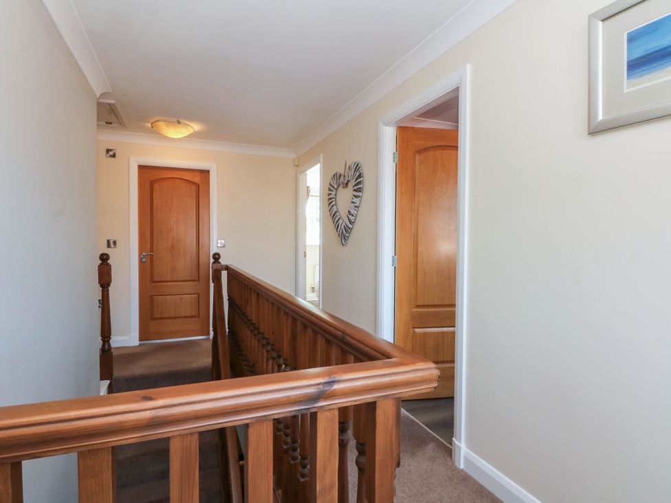 A hallway with wooden railing and doors at The Ferns in Kirkham