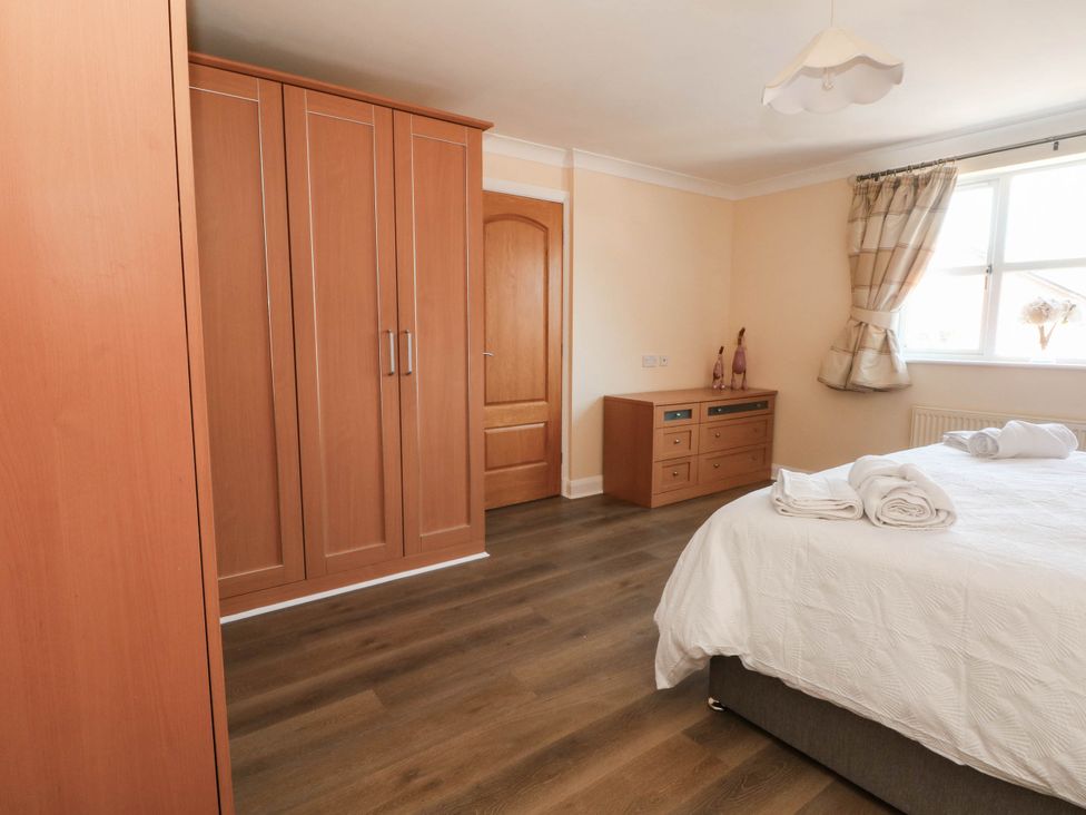 A bedroom with a wardrobe and bedside table at The Ferns in Kirkham