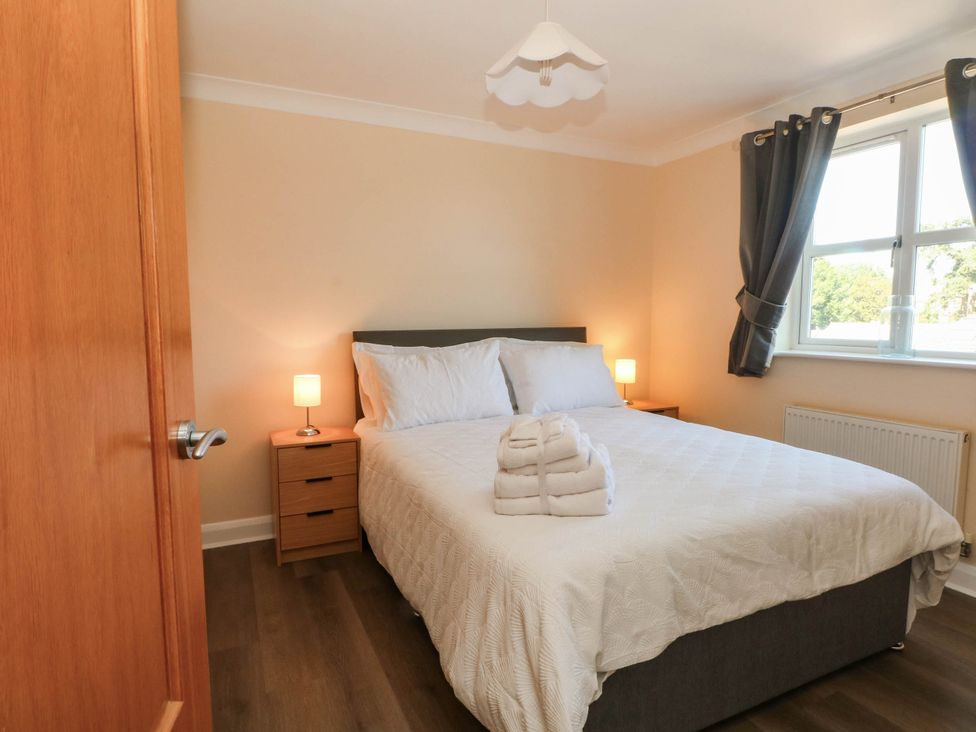 A bedroom with a bed and nightstand at The Ferns in Kirkham