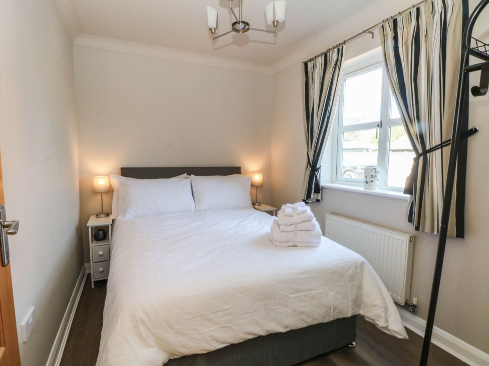 A bedroom with a bed and nightstand at The Ferns in Kirkham