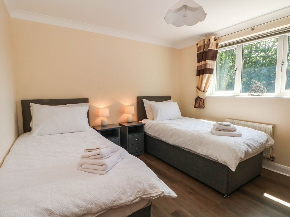 A bedroom with two single beds and a nightstand at The Ferns in Kirkham