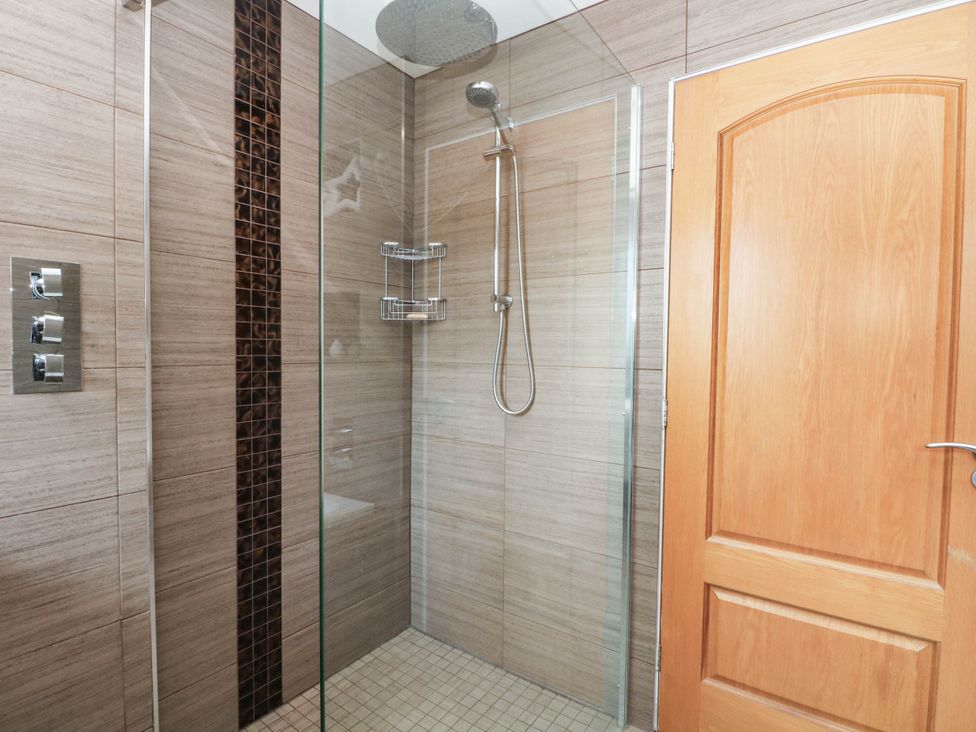 A shower with glass enclosure and controls at The Ferns in Kirkham