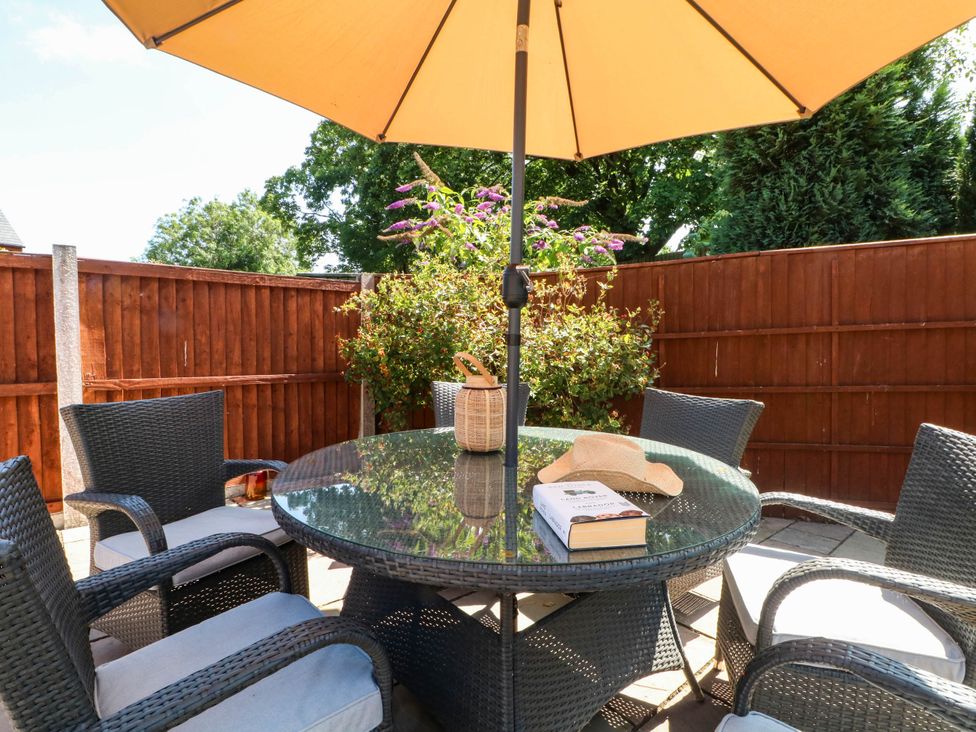 A patio with a table and chairs under an umbrella at The Ferns in Kirkham
