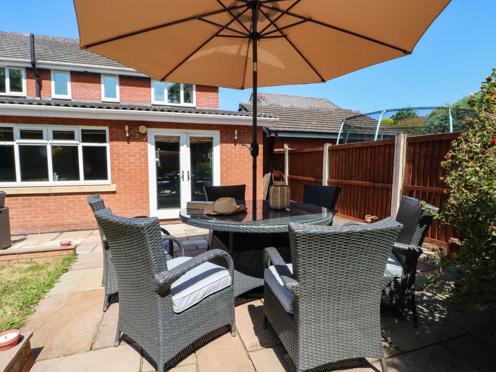 An outdoor area with a table and chairs under an umbrella at The Ferns in Kirkham