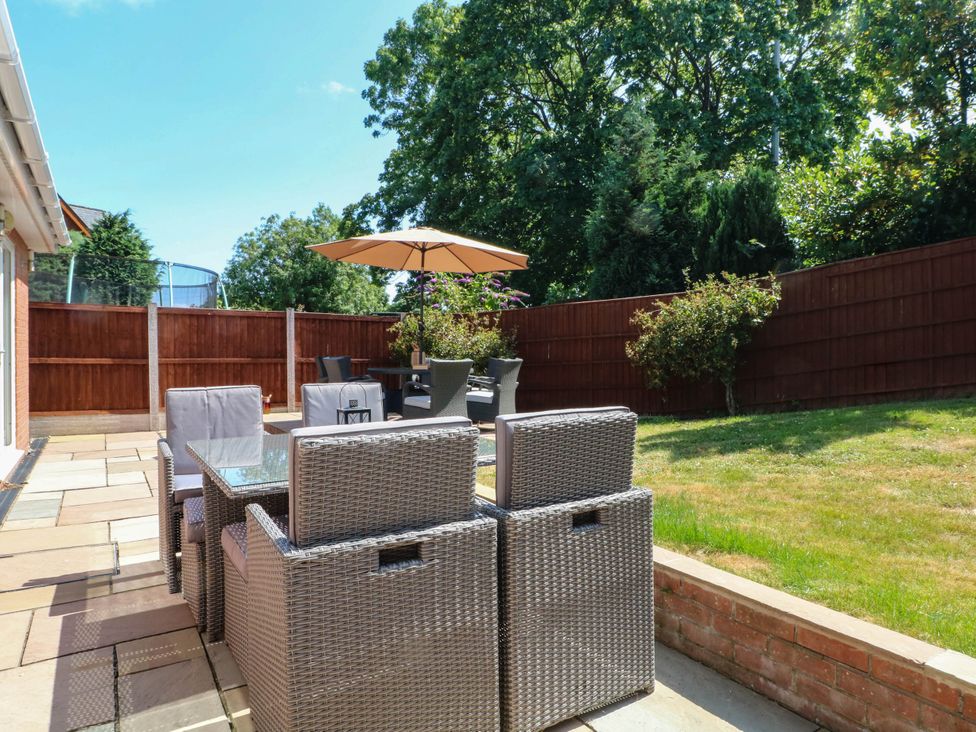 A garden with outdoor seating and a parasol at The Ferns in Kirkham