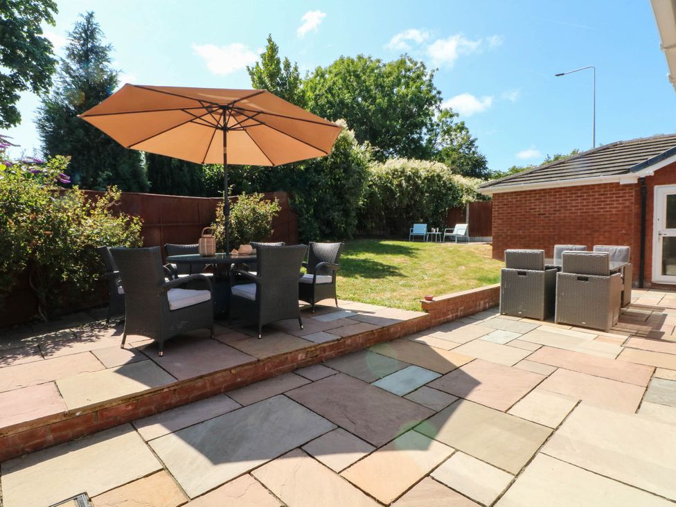 A garden with a dining area under an umbrella at The Ferns in Kirkham