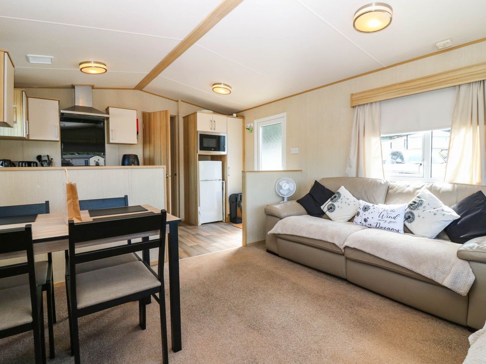A living room with a kitchen area and dining table at Rowan View 251
