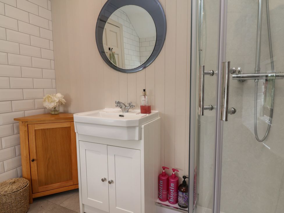 A bathroom with sink and shower at Tenandeleven Cottage Denbigh