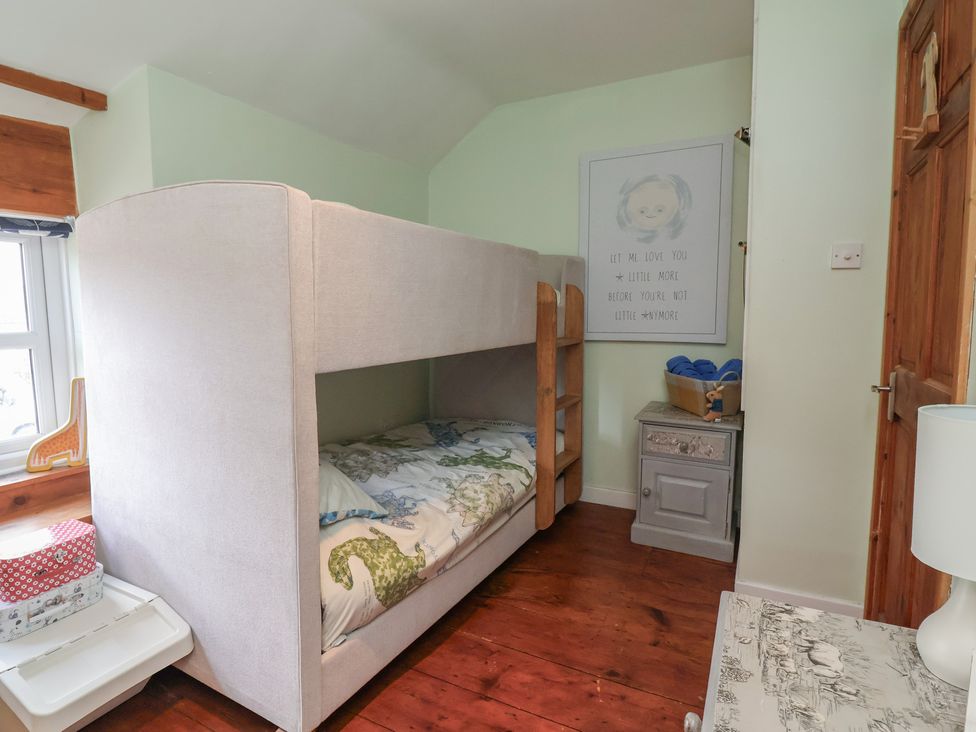 A bunk bed in a bedroom at Tenandeleven Cottage Denbigh