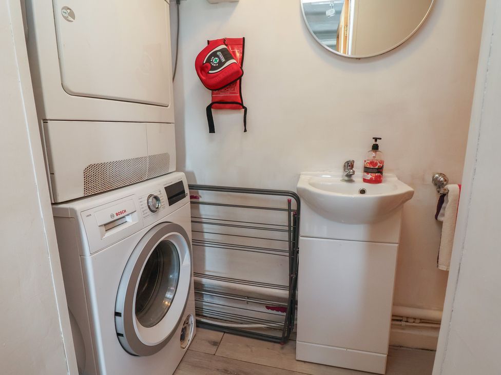 A laundry room with a washer and dryer and a sink at Tenandeleven Cottage Denbigh