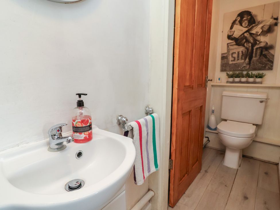 A bathroom with a sink and toilet at Tenandeleven Cottage, Denbigh