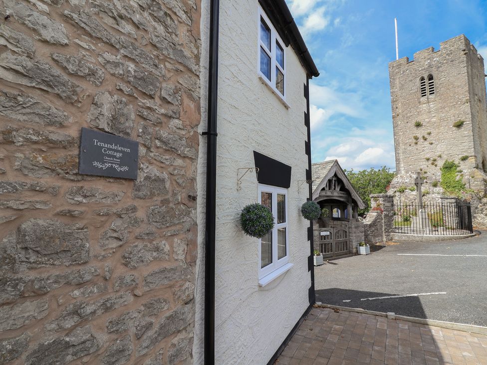An outdoor view of Tenandeleven Cottage and nearby tower in Denbigh