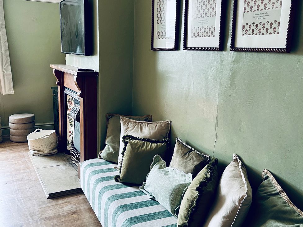 A living room with a sofa and television at Horseshoe Cottage in Macclesfield