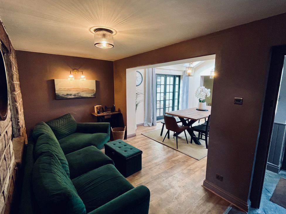 A living room with a sofa and side table at Horseshoe Cottage in Macclesfield