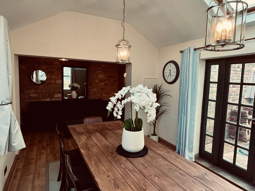 A dining room with a table and chairs at Horseshoe Cottage in Macclesfield
