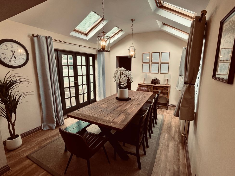 A dining room with a wooden table and chairs at Horseshoe Cottage in Macclesfield
