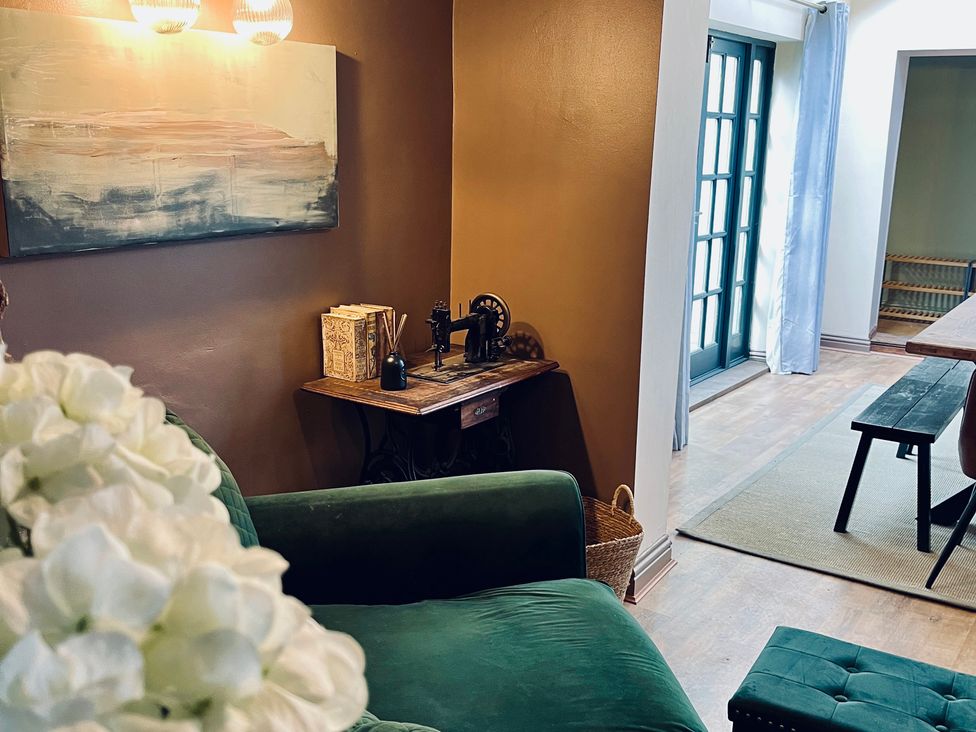 A living room featuring a sofa and sewing machine at Horseshoe Cottage in Macclesfield