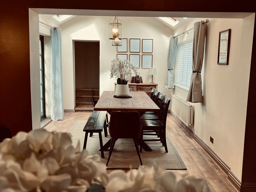 A dining room with a wooden table and chairs at Horseshoe Cottage Macclesfield