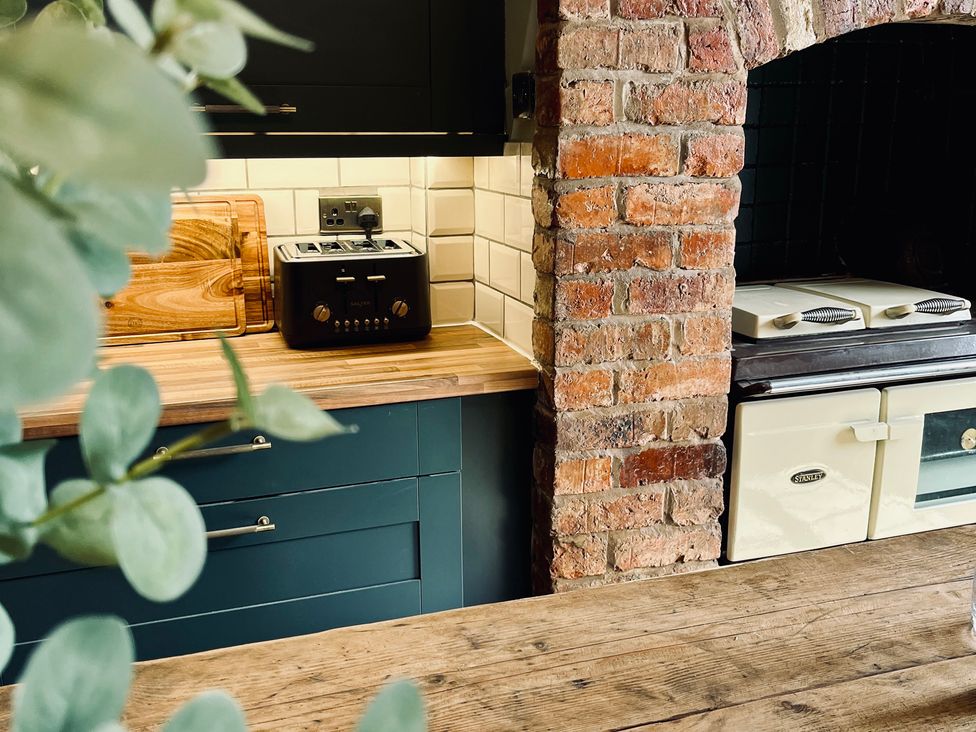 A kitchen with a toaster and chopping board at Horseshoe Cottage in Macclesfield