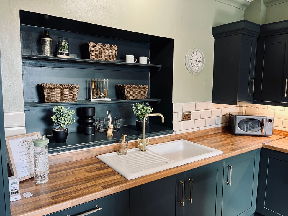 A kitchen with a sink and a microwave at Horseshoe Cottage in Macclesfield