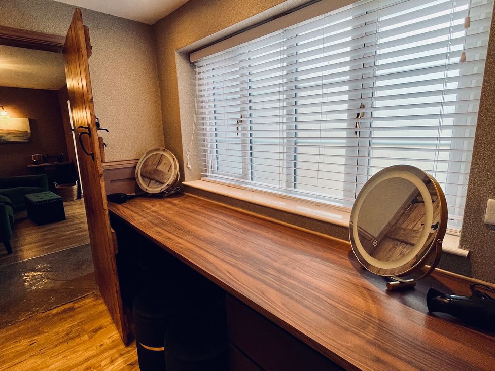 A dressing room with a table and mirror at Horseshoe Cottage, Macclesfield