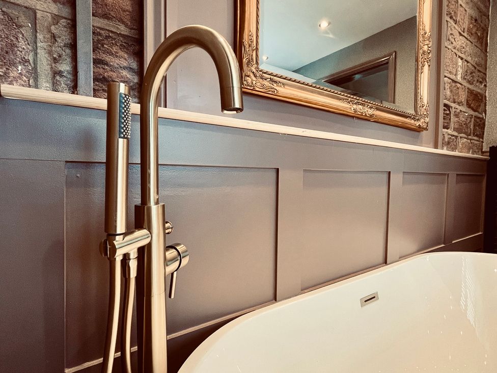 A faucet and bathtub in a bathroom at Horseshoe Cottage in Macclesfield