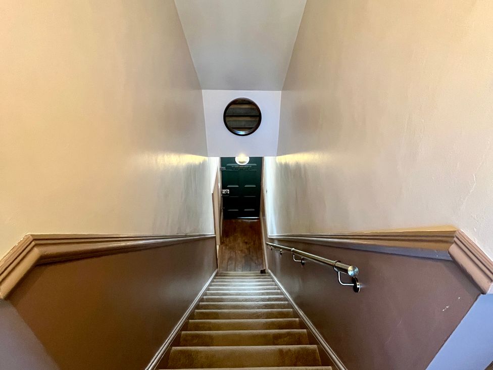A stairway view with stairs and a handrail at Horseshoe Cottage in Macclesfield