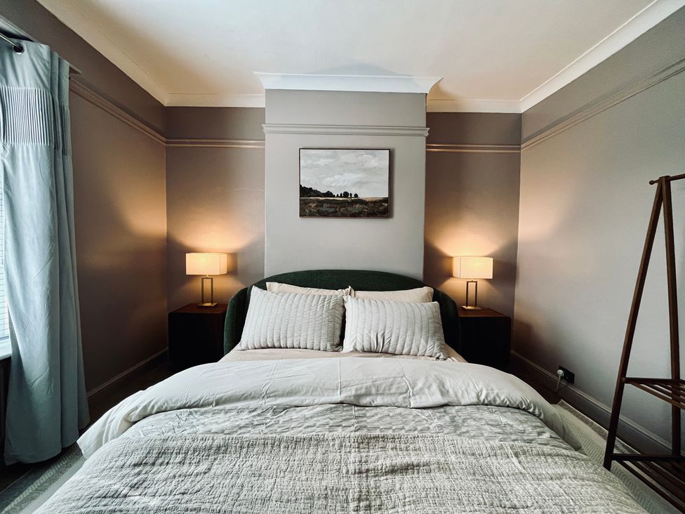 A bedroom with a bed and lamps at Horseshoe Cottage in Macclesfield