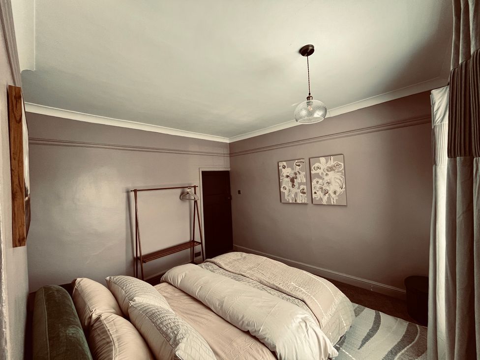 A bedroom with a bed and wall art at Horseshoe Cottage in Macclesfield