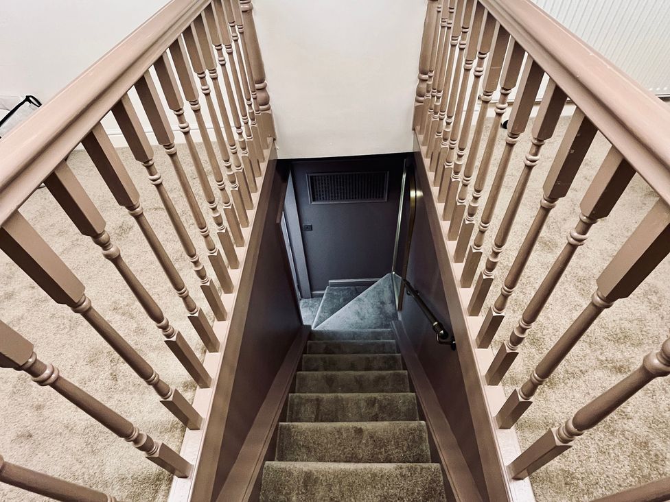A staircase with carpet leading down in Horseshoe Cottage Macclesfield