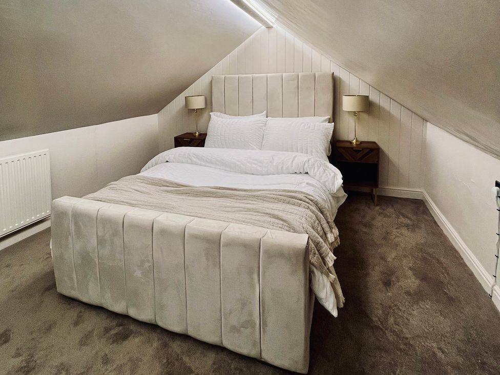 A bedroom with a bed and nightstands at Horseshoe Cottage in Macclesfield
