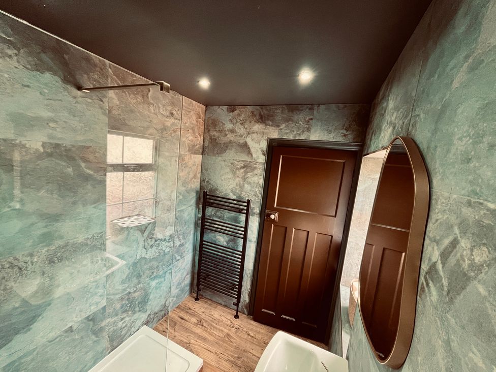 A bathroom with shower and mirror at Horseshoe Cottage in Macclesfield