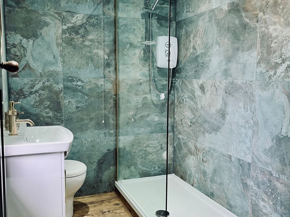 A bathroom with a toilet, sink, and shower at Horseshoe Cottage in Macclesfield