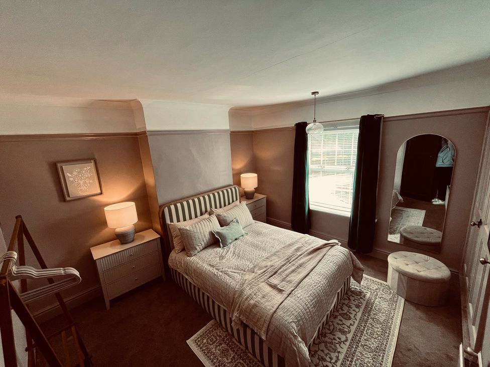 A bedroom with a bed and lamps at Horseshoe Cottage in Macclesfield