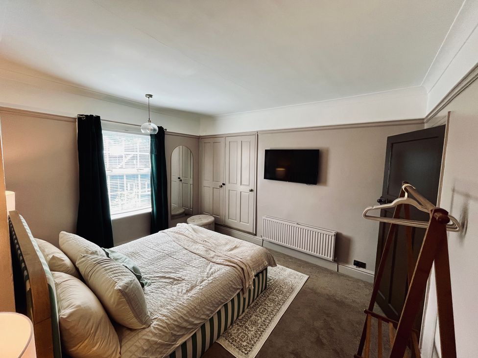 A bedroom with a bed and television at Horseshoe Cottage in Macclesfield