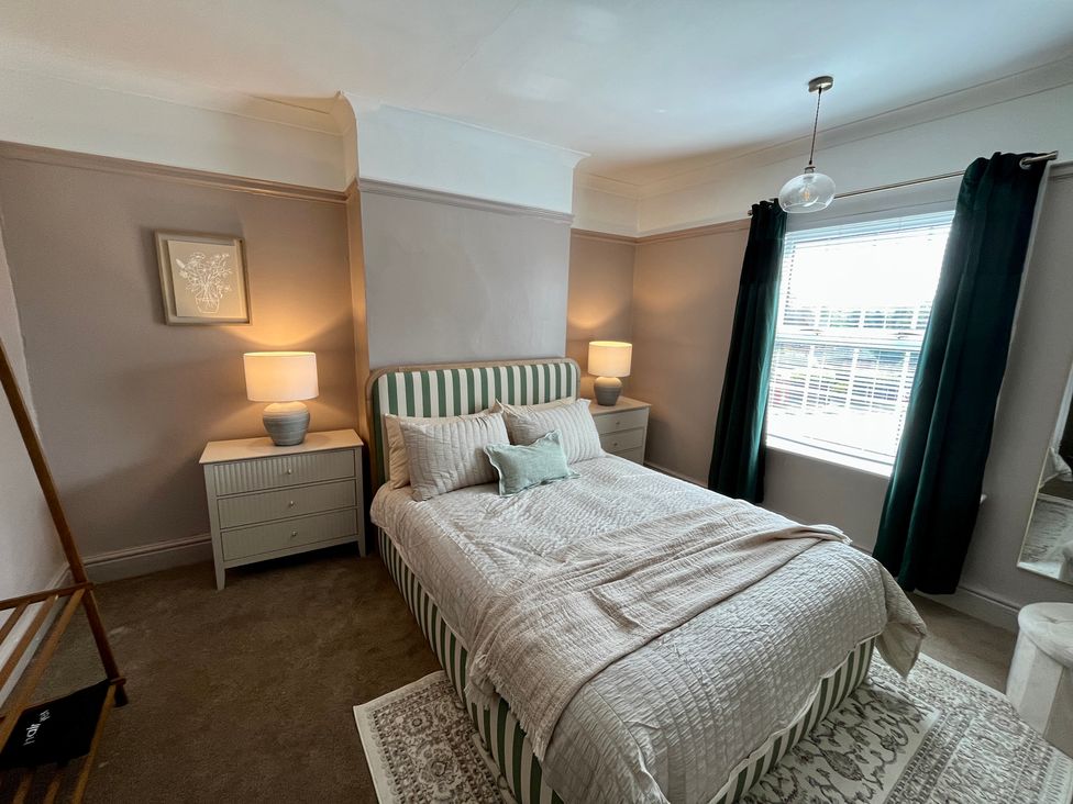 A bedroom with a bed and bedside table at Horseshoe Cottage in Macclesfield