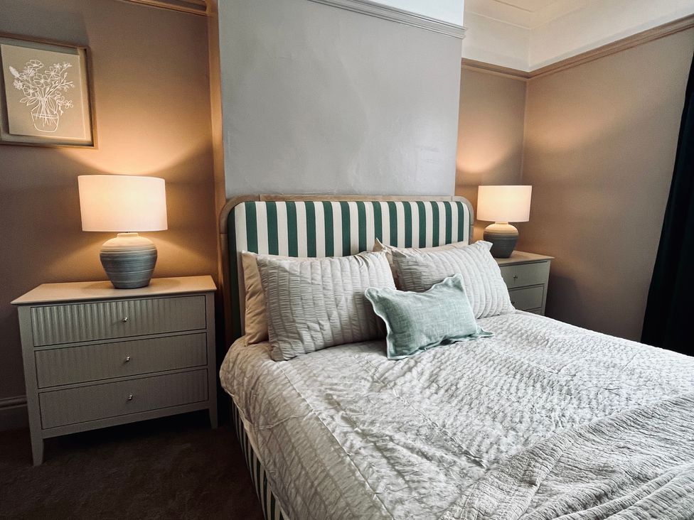 A bedroom with a bed and bedside tables at Horseshoe Cottage in Macclesfield