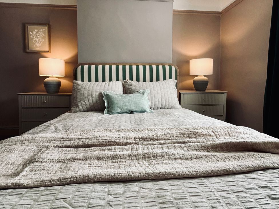 A bedroom with a bed and lamps at Horseshoe Cottage in Macclesfield