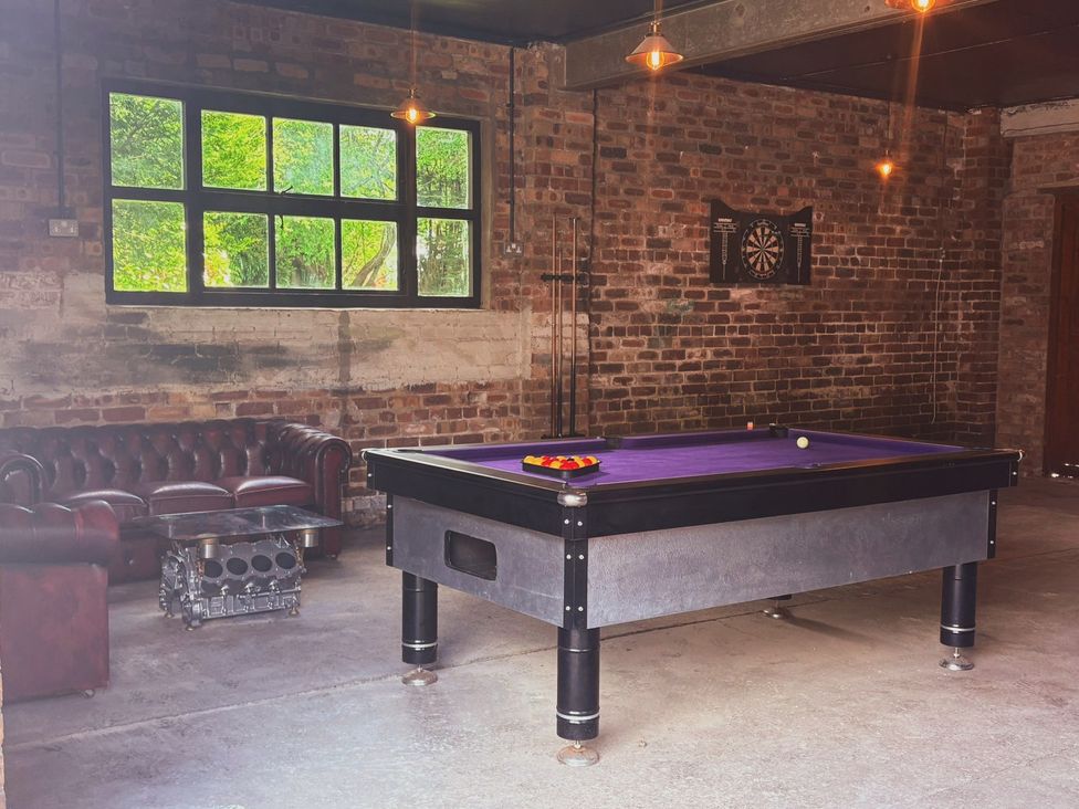 A game room with a billiard table and a couch at Horseshoe Cottage in Macclesfield