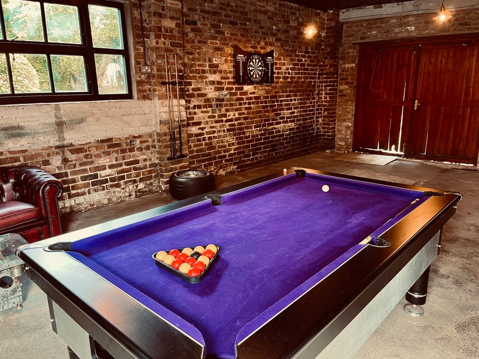A recreation room with a pool table and a dartboard at Horseshoe Cottage in Macclesfield