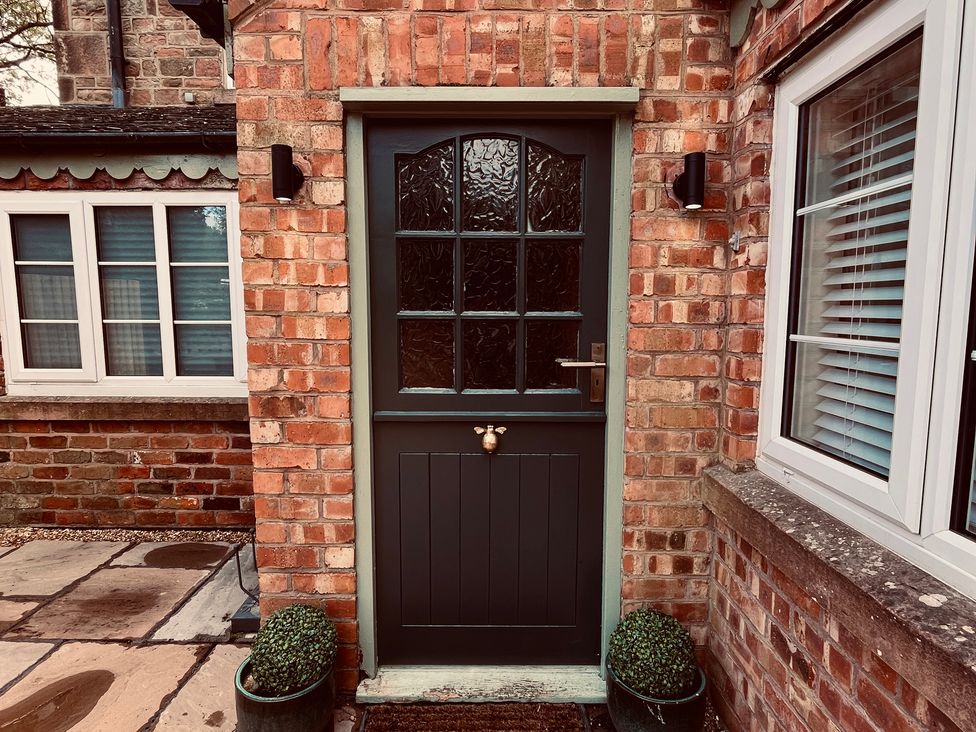 An entrance with a door and window at Horseshoe Cottage in Macclesfield