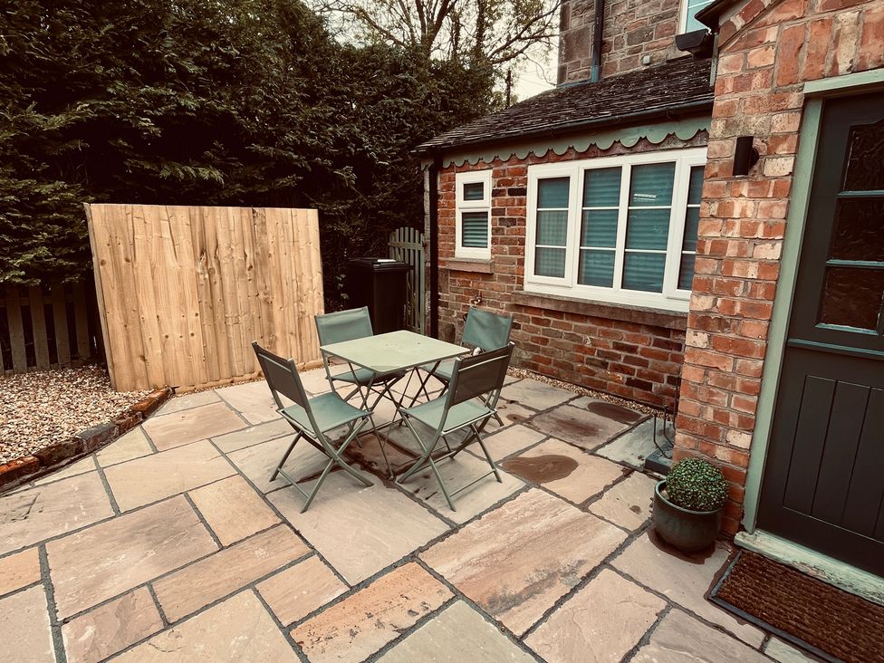 A patio area with a table and chairs at Horseshoe Cottage in Macclesfield