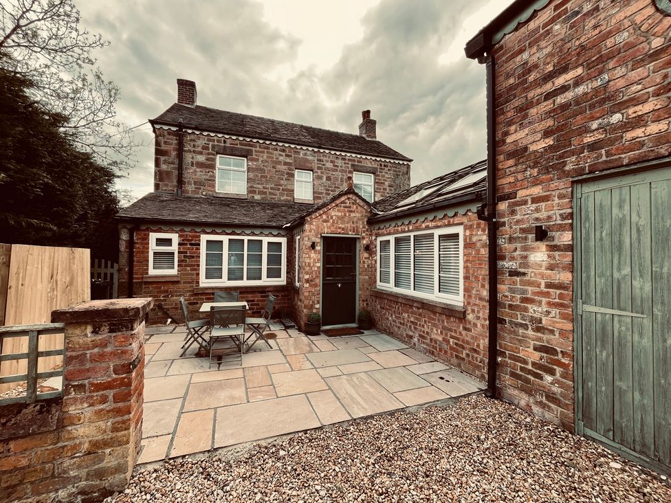 An outdoor area with a table and chairs at Horseshoe Cottage in Macclesfield