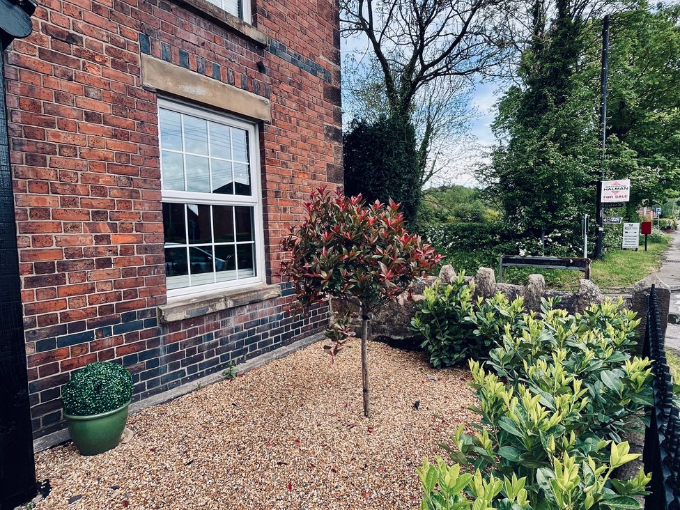 An outdoor space with a tree and gravel at Horseshoe Cottage in Macclesfield
