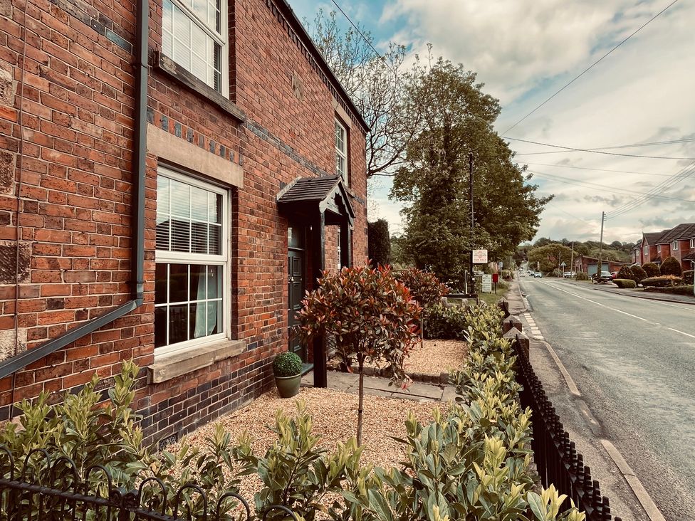 A brick exterior with windows and a front door at Horseshoe Cottage in Macclesfield