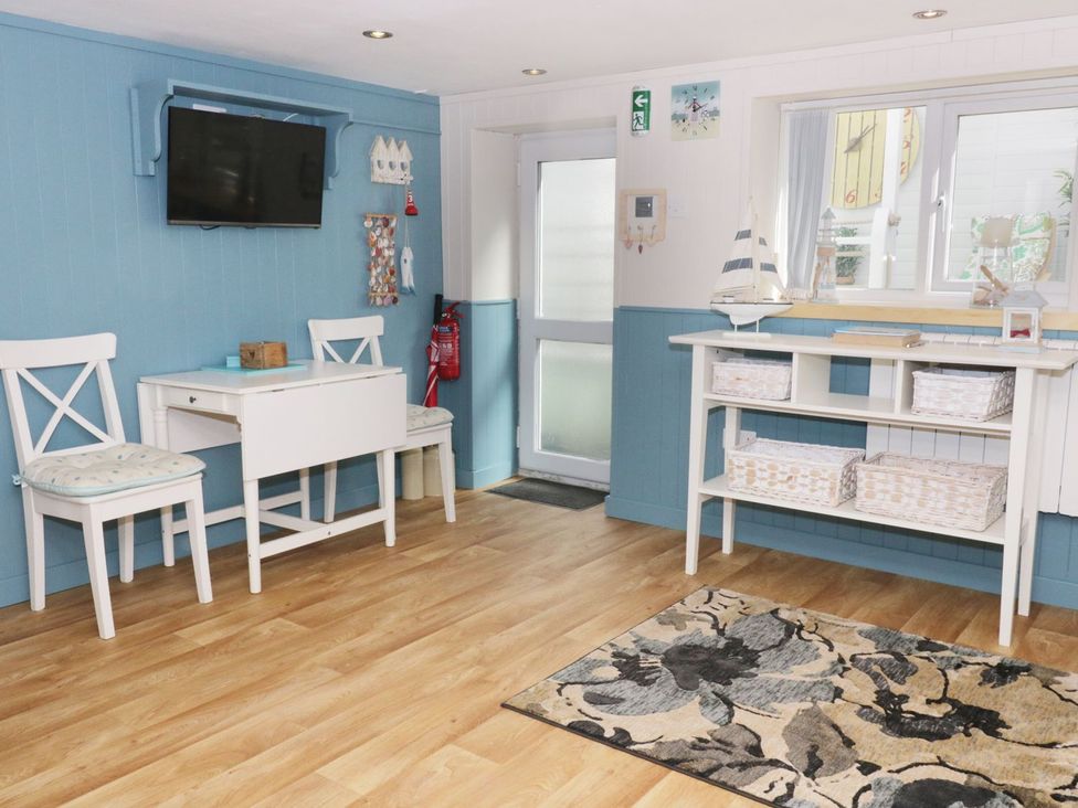 A study area with a desk and chairs at The Hideaways in Tyn-y-Gongl
