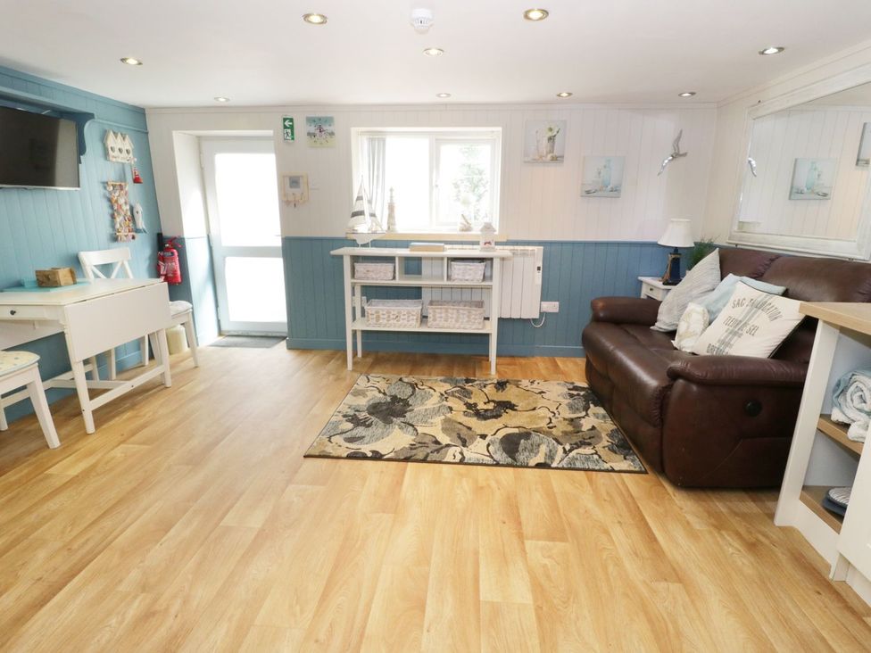 A living room with a television and an armchair at The Hideaways Tyn-y-Gongl