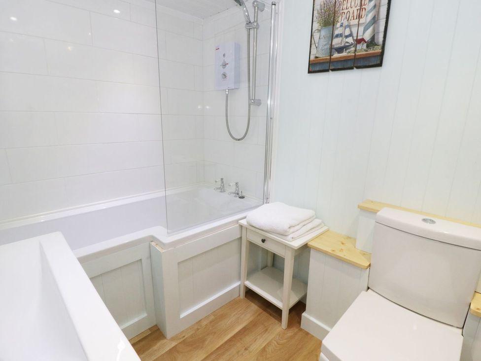 A bathroom with a bathtub and shower at The Hideaways in Tyn-y-Gongl