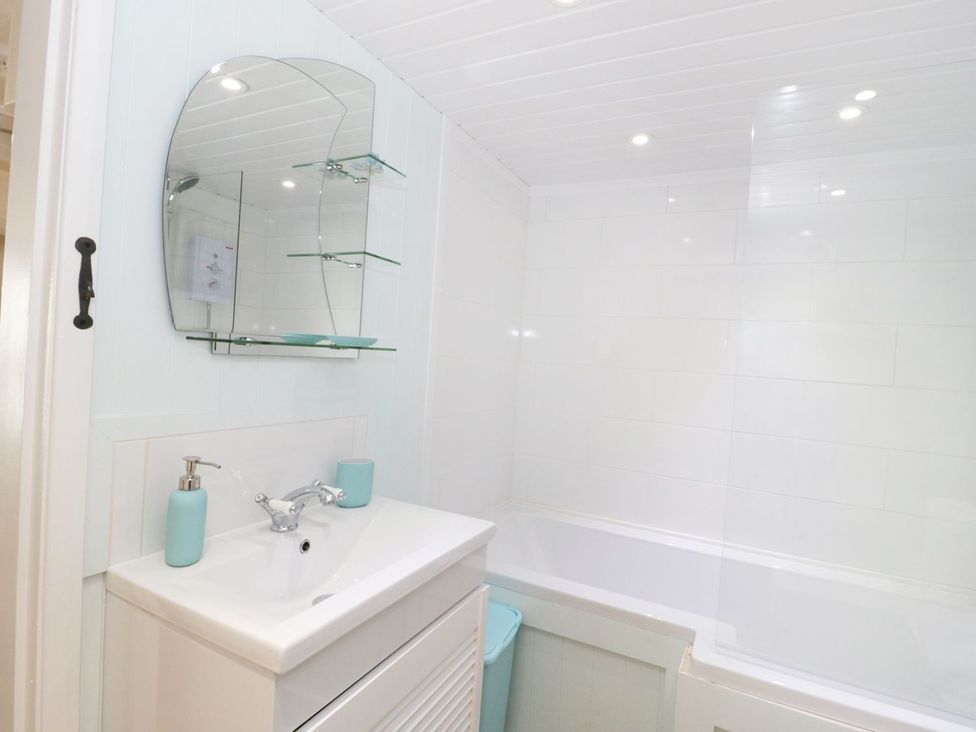 A bathroom with a sink and a bath tub at The Hideaways Tyn-y-Gongl