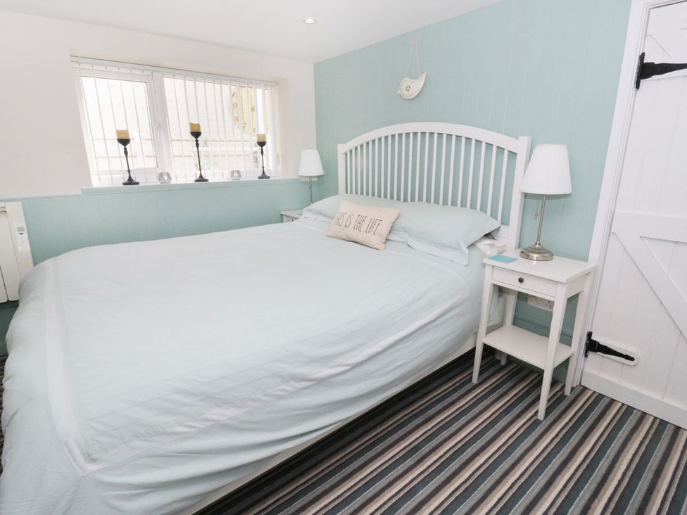 A bedroom with a bed and bedside table at The Hideaways in Tyn-y-Gongl